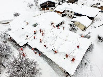 Viele DLRGler räumen ein Dach vom Schnee